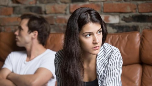 Couple is watching TV in the bed and the wife is unhappy with the channel