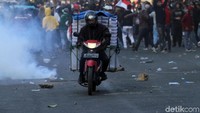 Sejumlah pengendara nekat melintas meski jalan tersebut sedang ada aksi yang berujung bentrok.
