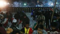 Massa aksi berlarian untuk menghindari asap yang ditimbulkan oleh gas air mata.