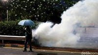 Beberapa menggunakan payung untuk menangkis tembakan gas air mata.
