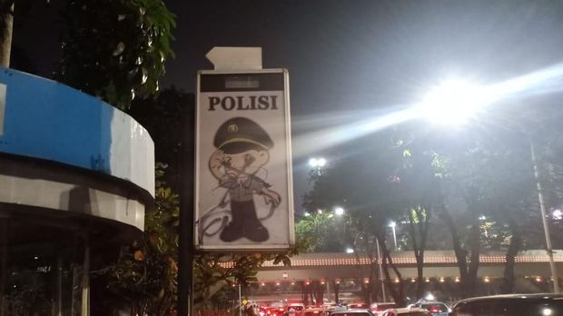 Pelang polisi dicoret oleh massa.