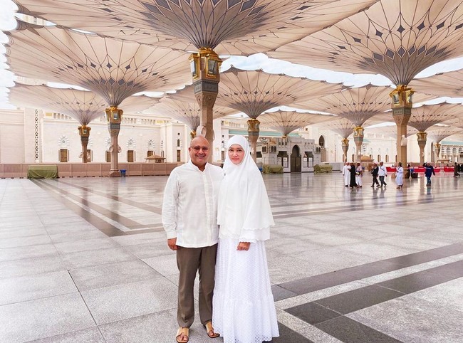 Maia dan Irwan Mussry berpose di antara payung-payung Masjid Nabawi. Keduanya kompak memakai busana putih. Maia tampil anggun dalam balutan hijab syari dan gamis putih. Selalu menyempatkan diri mengabadikan gambar bersama suami..@irwanmussry (maklum, ini pertama kali umroh dengan suami tercinta), tulisnya pada keterangan foto. Foto: instagram @maiaestiantyreal