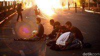 Kobaran api terlihat diantara massa yang tengah menunaikan salat maghrib di kawasan DPR.