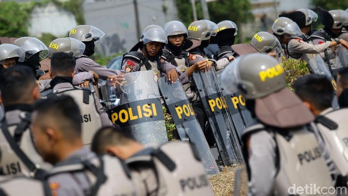 Sejumlah petugas kepolisian berpakaian lengkap bersiaga di depan gedung DPR. Pengamanan dilakukan terkait aksi demo yang akan digelar massa di depan gedung itu.