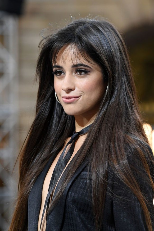 Camila Cabello bergaya dengan blazer yang tidak dikancing saat melenggang di Paris Fashion Week 2019. Gayanya dilengkapi dengan aksesori pita hitam yang dijadikan choker. Foto: Pascal Le Segretain/Getty Images
