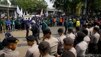 Massa mahasiswa nampak menggelar aksi demo di kawasan gedung DPR, Jakarta. Nampak pula sejumlah polisi bersiaga di salah satu sisinya.