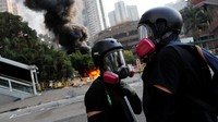 Dua orang demonstran nampak mengenakan masker khusus saat ikut serta dalam aksi demo yang bertetapatan dengan HUT ke-70 China di kawasan Wong Tai Sin, Hong Kong, Selasa (1/10/2019). Tyrone Siu/Reuters.