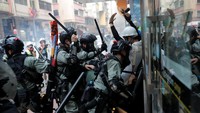 Polisi antihuru hara nampak mengamankan sejumlah demonstran yang ikut serta dalam aksi unjuk rasa yang digelar bertepatan dengan HUT ke-70 China. Susana Vera/Reuters.