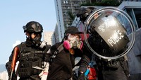 Seorang demonstran diamankan oleh polisi antihuru hara di Hong Kong. Tyrone Siu/Reuters.