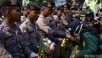 Massa mahasiswa dari berbagai universitas kembali menggelar aksi unjuk rasa di kawasan gedung DPR, Jakarta, Selasa (1/10/2019). Hal menarik dari aksi kali ini, para mahasiswa nampak membawa bunga untuk diberikan kepada polisi dan TNI yang berjaga di sana.