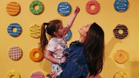 Di dinding donat warna-warni, Pia begitu mencuri perhatian dengan pose fotonya. Ia menggendong seorang anak perempuan cantik. Foto: Instagram piawurtzbach