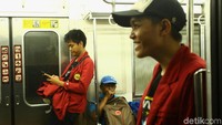 Para mahasiswa menaiki kereta dengan tertib.