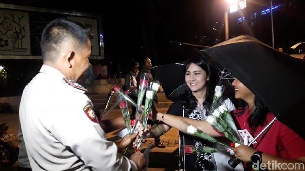 Warga bagikan bunga kepada pengunjung Monas dan polisi