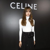 Lisa Blackpink mengeluarkan sisi chic-nya dalam balutan atasan turtle neck putih, berikut rok hitam berkilauan dan boots senada. (Foto: Pascal Le Segretain/Getty Images)