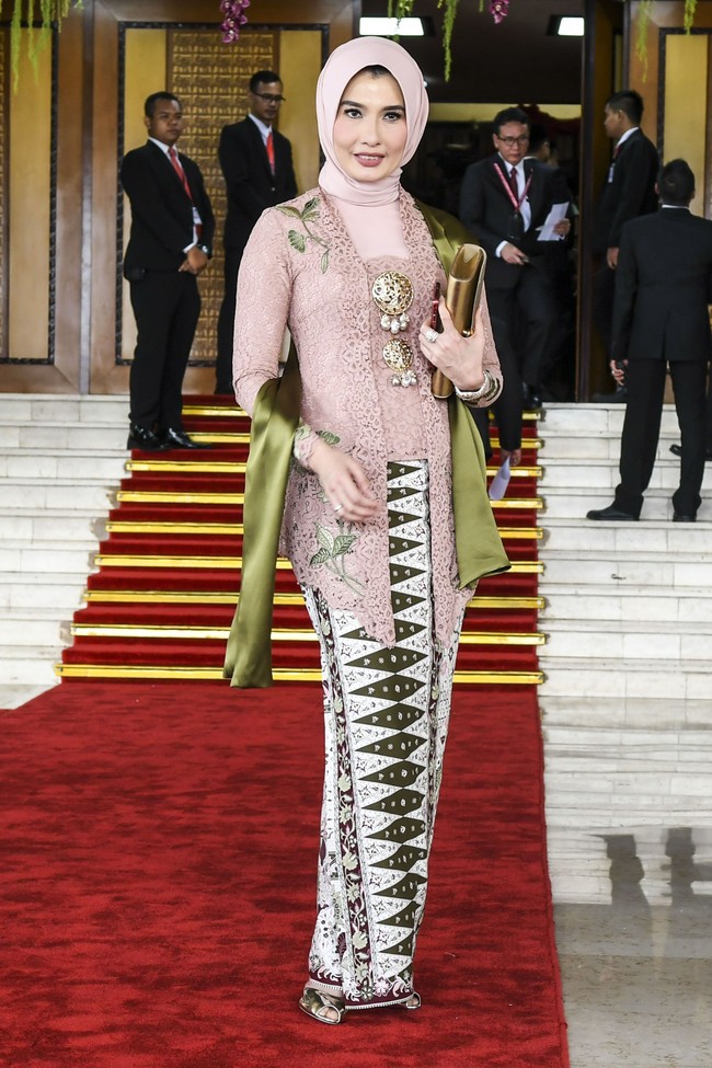 Arzeti Bilbina yang diusung sebagai anggota DPR oleh Partai Kebangkitan Bangsa (PKB) mewakili daerah Jawa Timur 1 tampil anggun di hari pelantikannya. Arezeti memakai hijab segi empat yang dililit rapi tanpa memakai inner hijab. Untuk busana, mantan peragawati itu mengenakan kebaya warna dusty pink dan aksesori rbos warna emas. Foto: Dok. Antara Foto