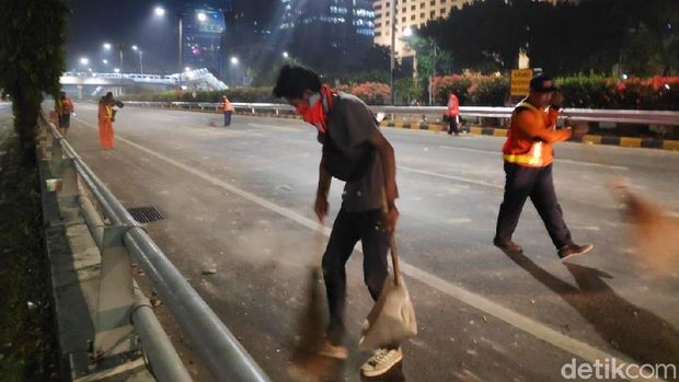 Petugas membersihkan batu-batu dari Tol Dalkot