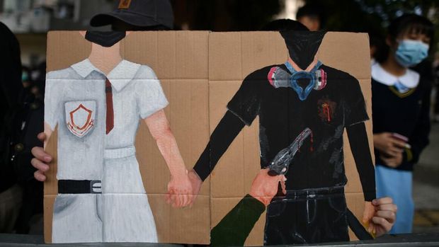 Poster yang menggambarkan penembakan oleh polisi dibawa salah satu demonstran