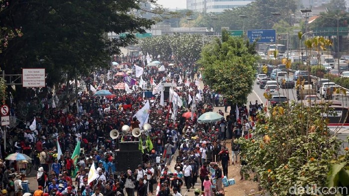 Massa buruh menggelar aksi unjuk rasa di depan gedung DPR, Jakarta. Saat menggelar aksi ada saja massa buruh yang masuk ke jalan tol.