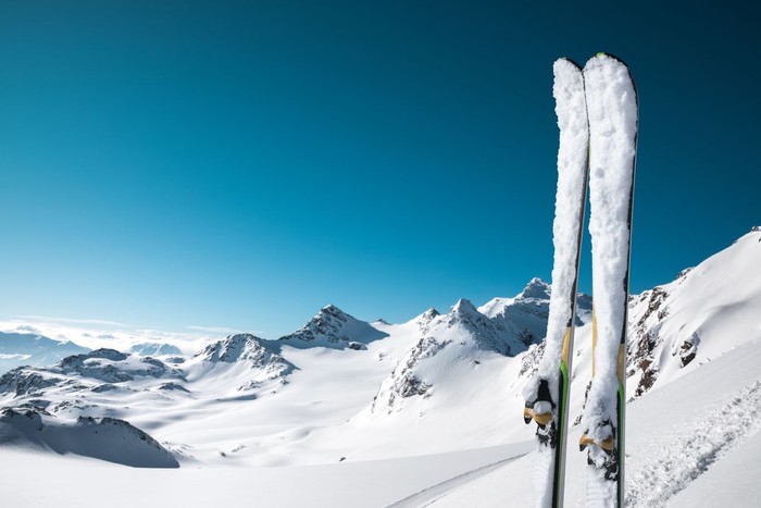 Panoramic view on snowcapped skis on the top of ski slope with view on the mountains. Val Thorens, France.