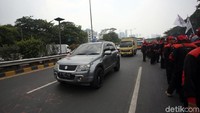 Sejumlah kendaraan nampak melintas di samping para peserta aksi yang berunjuk rasa di depan gedung DPR, Jakarta.