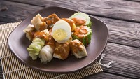 Siomay adalah makanan khas Indonesia yang terdiri dari pangsit ikan kukus berbentuk kerucut, telur, kentang, kol, tahu, dan pare. Setelah dikukus, semua bahan disusun di atas piring, dipotong-potong, dan disiram dengan saus kacang pedas. Dok. iStock