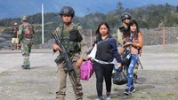Warga mengungsi dengan penjagaan aparat keamanan di Bandara Ilaga. ANTARA FOTO/Sevianto Pakiding.