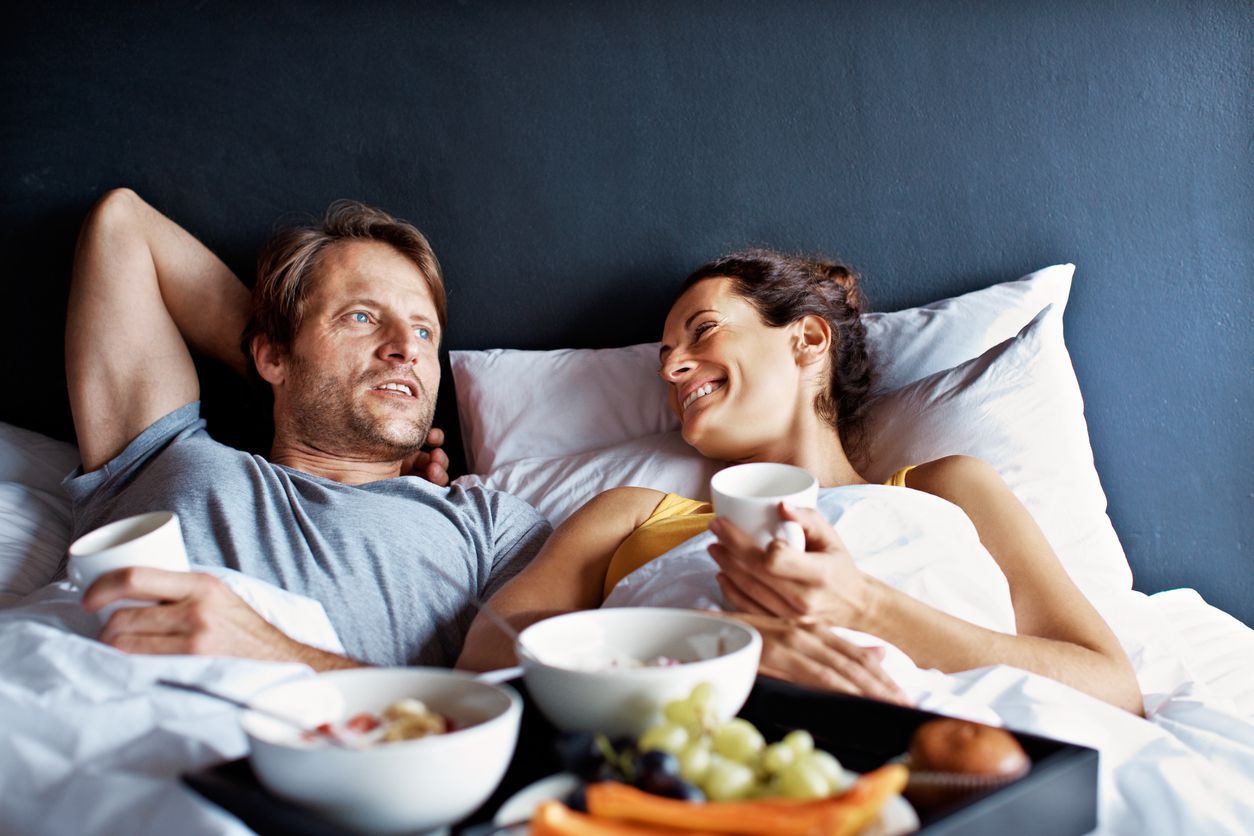 Shot of a mature couple relaxing in bed with breakfast