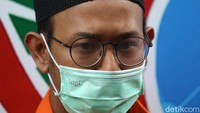 Rifat Umar tampak berbaju tahanan dan memakai masker.