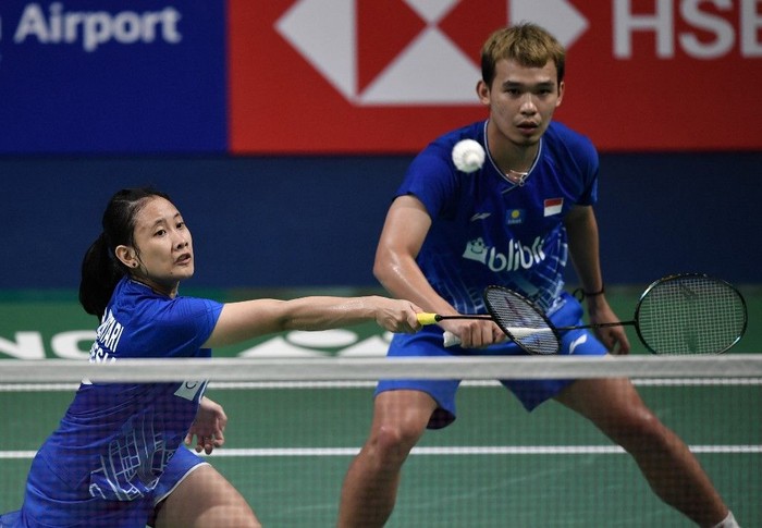 Indonesias Pitha Haningtyas Mentari (L) plays a shot as teammate Rinov Rivaldy looks on during the mixed doubles semi-final match against Thailands Dechapol Puavaranukroh and Sapsiree Taerattanachai at the Korea Open badminton tournament in Incheon on September 28, 2019. (Photo by Jung Yeon-je / AFP)