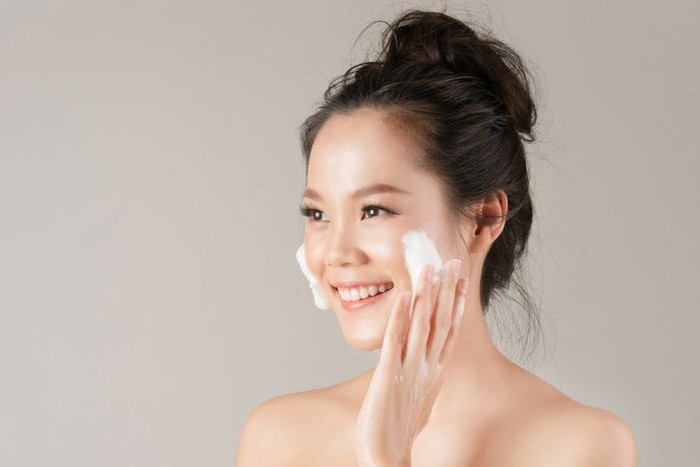 Shot of a beautiful young woman feeling her skin during her beauty routine at home