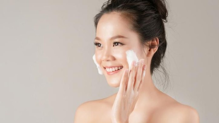 Shot of a beautiful young woman feeling her skin during her beauty routine at home