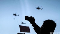 Warga menyaksikan berbagai pesawat tempur milik TNI bermanuver di langit Jakarta.