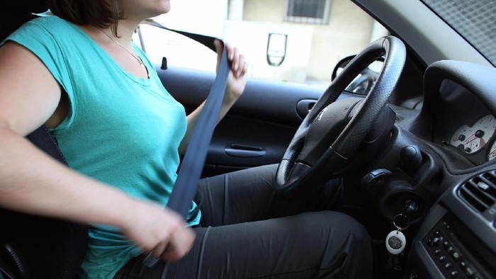 A woman buckles a safety belt in Paris on June 30, 2013. France made wearing safety belts compulsory on July 1, 1973 for the front seats of cars. Despite opposition from civil liberties defenders, safety belts have helped reduce the number of road deaths, and are now widely accepted.