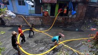 Warga harus nyemplung ke sungai untuk membantu petugas damkar memadamkan api.