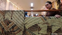 Seorang pengunjung melihat kain batik yang dipamerkan.