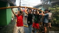 Warga membantu mendekatkan selang ke titik api.