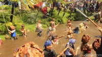 Atraksi sembur menyembur air atau perang cai yang dilakukan sesepuh adat dan mojang desa ke arah penonton membuat suasana menjadi semarak. Mereka menembakkan air dari tengah telaga yang airnya berasal dari mata air setempat (Yudha Maulana/detikcom)