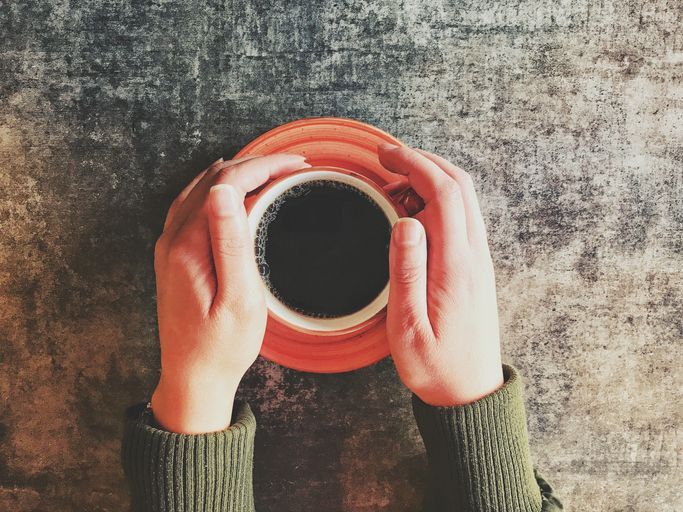 a cup of black coffee in hands