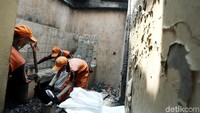 Petugas Penanganan Sarana dan Prasarana Umum (PPSU) membantu membersihkan puing-puing sisa kebakaran.