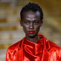 Makeup artist Nami Yoshida membuat tampilan makeup yang glowing untuk model Sies Marjan. Yoshida menggunakan pelembab pada wajah untuk membuat tampilan kulit terliat lebih mengkilap. Untuk menyempurnakannya, Yoshida menggunakan lip gloss berwarna merah. Foto: Getty Images