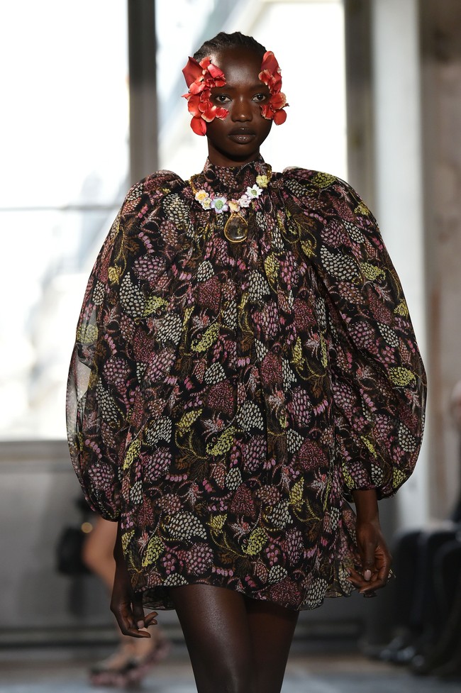 Gaya yang ditampilkan oleh peragaan busana dari Giambattista Valli cukup menarik perhatian. Model yang tampil di Paris Fashion Week ini terlihat menggunakan kelopak bunga berwarna merah pada bagian wajahnya.Foto: Getty Images