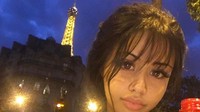 Dalam foto ini, Rojean nampak imut berfoto dengan pemandangan ujung menara Eiffle yang menyala. Jadi salah fokus dengan gelas minuman di depannya. Foto: Instagram @yungsweetro