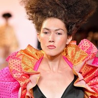 Gaya fashion yang nyentrik ini dikenakan oleh model dari Christopher John Rogers. Dalam fashion show tersebut, rambut sang model terlihat ditata ke arah atas. Untuk makeup, model terlihat seperti hanya menggunakan lip liner untuk membentuk bibir, blush on dan sedikit eyeshadow berwarna soft pink. Foto: Getty Images