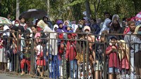 Para penonton memenuhi jalan-jalan yang dilalui peserta karnaval.