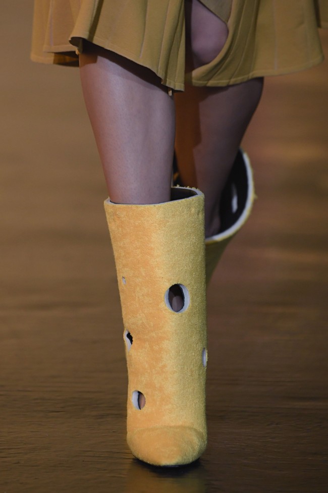 Buat kamu yang suka tampil quirky, Off-White memiliki boots dengan aksen bolongan seperti keju swiss. (Foto: Getty Images)