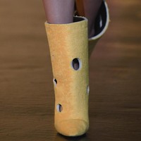Buat kamu yang suka tampil quirky, Off-White memiliki boots dengan aksen bolongan seperti keju swiss. (Foto: Getty Images)