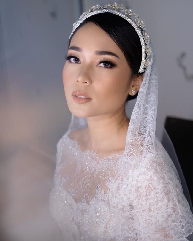 Ayla dan Rama menikah di Four Seasons Jakarta. Ayla tampak cantik dengan riasan flawless makeup artist Bubah Alvian. Ia pun terlihat anggun dengan headpiece Rinaldy A. Yunardi. Foto: Instagram @woko_s