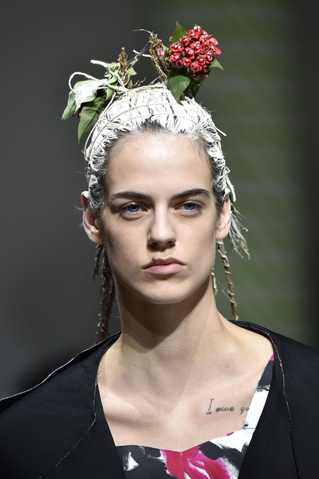Peragaan busana yang ditampilkan oleh Marni dalam Milan Fashion Week Spring/Summer 2020 ini cukup unik. Marni menampilkan gaya rambut berwarna putih yang dihiasi seikat bunga kecil berwarna merah dan dedaunan. Foto: Getty Images