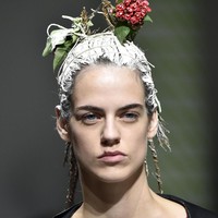 Peragaan busana yang ditampilkan oleh Marni dalam Milan Fashion Week Spring/Summer 2020 ini cukup unik. Marni menampilkan gaya rambut berwarna putih yang dihiasi seikat bunga kecil berwarna merah dan dedaunan. Foto: Getty Images