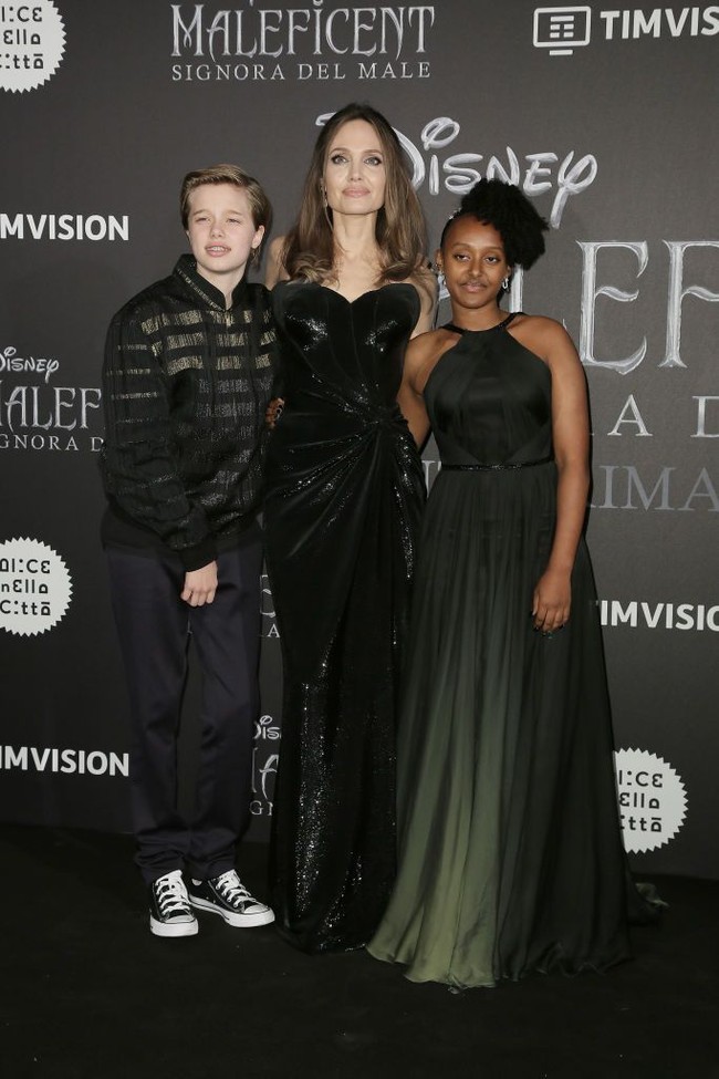 Untuk premier Maleficent 2 di Roma, Angelina membungkus tubuhnya dengan gaun hitam. Sementara itu kedua anaknya, Zahara dan Shiloh memilh busana hitam dengan sentuhan hijau army. (Foto: Getty Images)